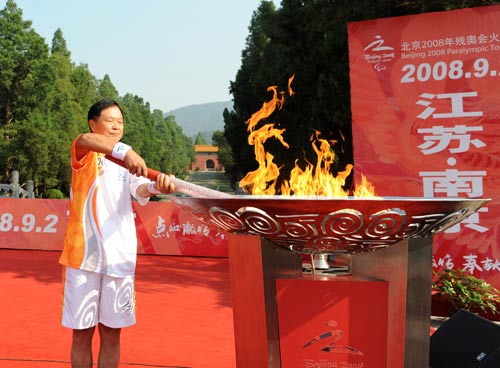 Photo: Torchbearer Zhou Zengfu lights the cauldron