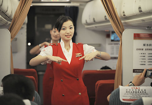 Air hostess Jiang Kangkang performs a sign language song 'Smiling' on board, August 30, 2008. Chinese air hostesses get ready for more hearing-challenged passengers during the upcoming Paralympic Games. [Xinhua]