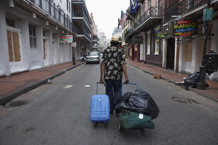 A man hauls bags down Bourbon Street in the French Quarter of New Orleans, Louisiana, ahead of Hurricane Gustav's arrival, August 31, 2008. Hurricane Gustav churned toward the Louisiana coast through the oil-rich Gulf of Mexico on Sunday with strength that could rival 2005's Hurricane Katrina, prompting low-lying New Orleans to begin evacuation. [Agencies]