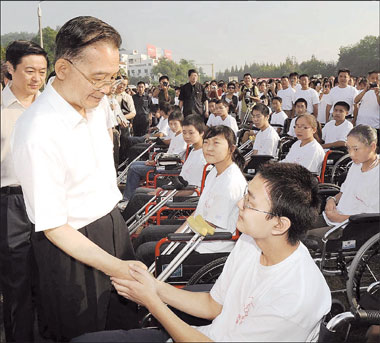 Premier Wen Jiabao talks to students yesterday at the Beichuan Middle School at the opening of its temporary quarters in the courtyard of the Changhong training center in Mianyang, Sichuan Province. The middle school was among the hardest-hit schools in the May 12 earthquake that killed nearly 70,000 people.