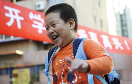 A grade one pupil runs into the Beijing No. 2 Experimental Primary School in Beijing, capital of China, Sept. 1, 2008. Middle schools and primary schools started the new semester in China on Monday. (Xinhua/Wu Xiaoling)