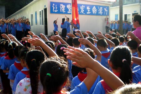 Pupils salute during the national flag raising ceremony for the begining of a new term at the Xingxian Elemantary School in the Yucheng District of Ya&apos;an City in the quake-hit Sichuan Province, southwest China, Sept. 1, 2008. Middle schools and primary schools started the new semester in China on Monday. (Xinhua/Chen Xie)