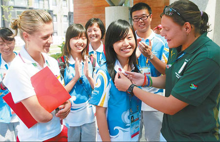 Natalie du Toit (right) and Natalia Partyka talk with volunteers at the Paralympic Village yesterday. [Yang Shizhong/China Daily] 