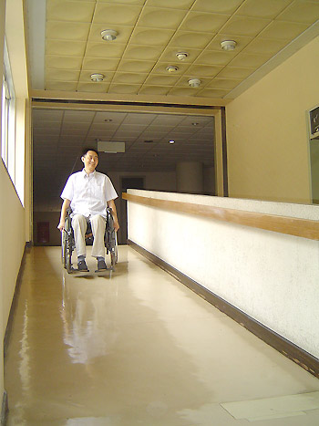 A wheelchair-user rolls down a ramp at Benevolence Hospital in Beijng on August 28, 2008. Twenty-two appointed hospitals in Beijing have undergone renovations.[Xinhua] 