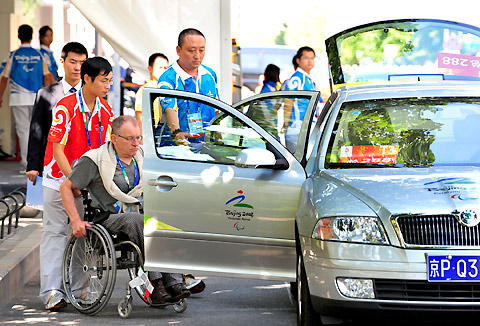 Volunteers help a Paralympic guest into a car September 2, 2008. The Paralympic Family Hotel is ready for the Games. [Xinhua] 