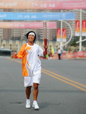 Torchbearer Zhao Yun runs during the Beijing 2008 Paralympics torch relay in Dalian, a coastal city of northeast China's Liaoning Province, Sept. 3, 2008. 