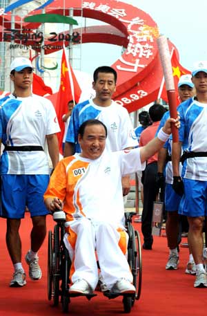 Torchbearer Li Yang holds the torch during the Beijing 2008 Paralympics torch relay in Dalian, a coastal city of northeast China's Liaoning Province, Sept. 3, 2008. 