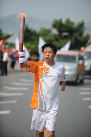 Torchbearer Qiu Xuewen runs during the Beijing 2008 Paralympics torch relay in Dalian, a coastal city of northeast China's Liaoning Province, Sept. 3, 2008. 