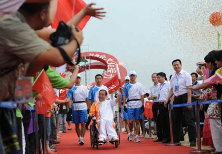 Torchbearer Li Yang holds the torch during the Beijing 2008 Paralympics torch relay in Dalian, a coastal city of northeast China's Liaoning Province, Sept. 3, 2008.