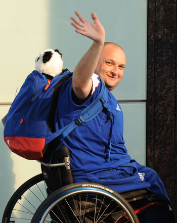  A Paralympic athlete wears a knapsack with his newly bought panda toy, waves in front of the camera as he arrives at Beijing Capital International Airport in Beijing, September 3, 2008. The Paralympic Games will kick off on Saturday. [Xinhua]