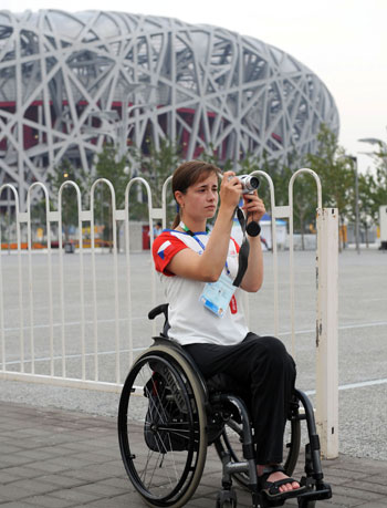 A Paralympic athlete snaps a photo in front of the National Stadium or 'Bird's Nest' in Beijing, September 3, 2008. The Beijing Paralympic Games will kick off on Saturday. [Xinhua]