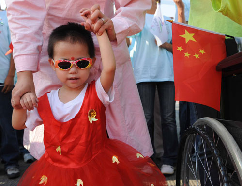 A girl from a local social welfare home cheers for the Paralympic torch during the Luoyang leg in Central China's Henan Province September 4, 2008. [Xinhua] 