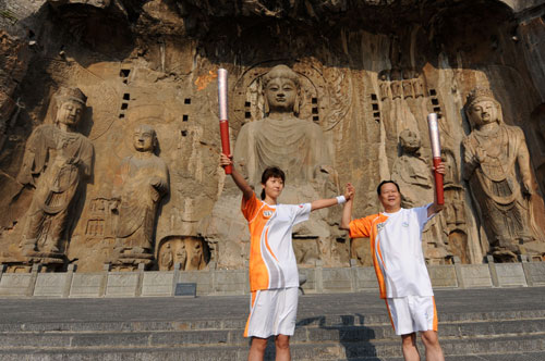 Two torchbearers display the Paralympic torch in front of the Long Men Grottes, one of the tour destinations of Luoyang in Central China's Henan Province September 4, 2008. [Xinhua] 