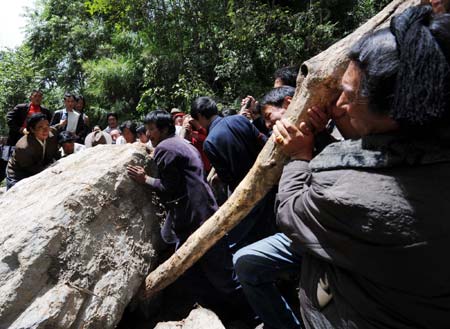 People try to move away the rock blocking the highway in Nyingchi, southwest China's Tibet Autonomous Region, Sept. 3, 2008. The collapsed part of Sichuan-Tibet highway was recovered Wednesday morning after soldiers' efforts in the past three days. Because of continuous rainfall lashing the Nyingchi prefecture over the past two weeks, a mud flow blocked the highway lingking Tibet with the neighboring Sichuan Province on Saturday.