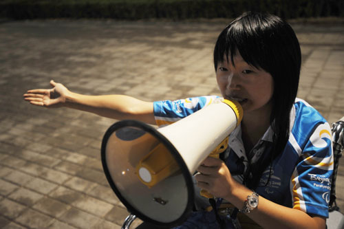 A Paralympic volunteer in a wheelchair uses a bullhorn to guide spectators attending the reheasal for the opening ceremonies of the 2008 Paralympic Games, September 4, 2008. [Xinhua] 
