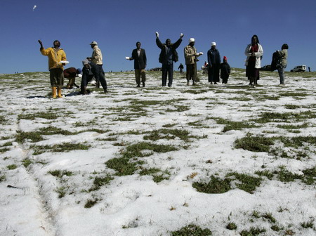 Villagers play with snow after heavy hailstorms hit a deforested hillside in Gikingi Village in Nyahururu town, some 220km from Nairobi, September 3, 2008. [Agencies]