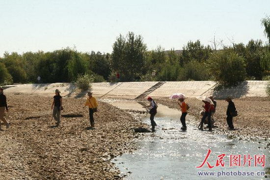 Tourists walk on the dry riverbed at Baiyanghe Canyon scenic area in Kalamay, Xinjiang Uygur Autonomous Region, on September 2, 2008. The most severe drought in ten years currently threatens the city in northwestern China. [Photo: Photobase.cn]