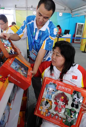 Chinese athlete purchases souvenirs in the help of a volunteer at the Paralympic Village in Beijing on September 5, 2008. Athletes and delegates from all over the world gathered in Beijing to attend the Beijing 2008 Paralympic Games which will be opened on September 6, 2008.