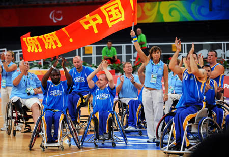 Swedish players raise a banner written "Thank you, China" after beating Japan in men