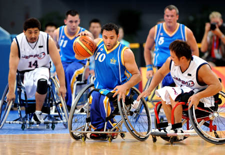 Sweden's Hussein Haidari(C) breaks through in men's wheelchair basketball heat against Japan at the Beijing 2008 Paralympic Games in Beijing, Sept. 7, 2008. Sweden won 61-49.