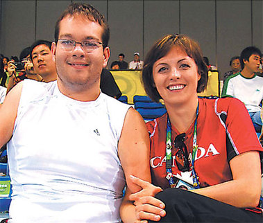 Canadian boccia player Joshua Vander Vies and his girlfriend Dalia Mykolaitiene, an assistant to boccia players, watch the preliminary rounds of the competition yesterday. [China Daily]