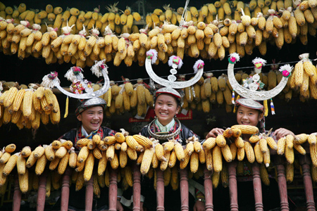 Women in traditional costumes watch performances from their wooden house during celebrations for the Duan Festival in Duyun, southwest China's Guizhou Province, September 7, 2008. 