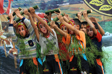 Children wearing masks of the Monkey King dance during celebrations for the Duan Festival in Duyun, southwest China's Guizhou Province, September 7, 2008.