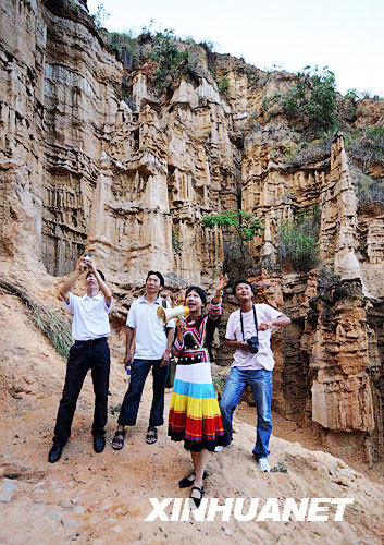 A tourist guide introduces the scenery inside the Yuanmou Clay Forest to visitors on September 7, 2008, with the reopening of the quake-damaged park after four days of cleaning-up. [Photo: Xinhuanet]