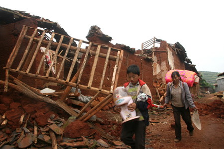 Quake-sufferers carry the re-found living necessities from the shattered houses at the quake-hit area of Huili County, southwest China's Sichuan Province Sept. 3, 2008. [Xinhua]