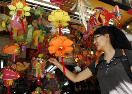 A pedestrian chooses lanterns for the Mid-Autumn Festival at a store in Hong Kong, south China, Sept. 7, 2008. The Mid-Autumn Festival, a traditional Chinese holiday for family reunion and mooncakes, falls on Sept. 14 this year. [Liu Lianfen/Xinhua]