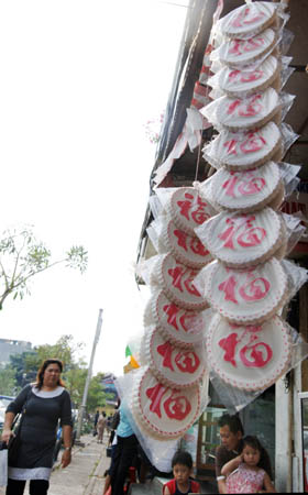 Moon cakes are hung on the outside of a shop at the China Town, Pancoran in Jakarta, Indonesia, Sept. 7, 2008. Large amount of moon cakes came into the market in Jakarta before the traditional Chinese Mid-Autumn Festival which falls on Sept. 14 this year. [Yue Yuewei/Xinhua]