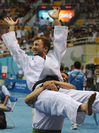 Mouloud Noura (top) is hoisted by his coach.