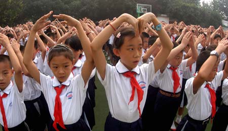 Students perform a song in sign language during a Teacher's Day celebration held at Daminghulu Primary School in Jinan, capital of east China's Shandong Province, Sept. 8, 2008.