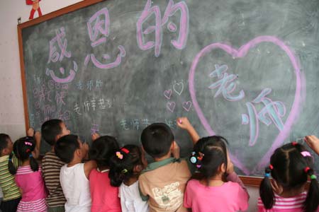 Children of a local kindergarten write down the greeting words on the blackboard to express their gratitude to their teachers in Chaohu, east China's Anhui Province, Sept. 8, 2008, ahead of the Teacher's Day that falls on Sept. 10. [Zhang Shenghao/Xinhua]