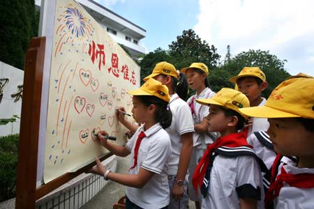 Pupils of Haishan Elementary School write greetings on the paper in the school to extend their gratitude to their teachers in Zhoushan, east China's Zhejiang Province, Sept. 8, 2008, ahead of the Teacher's Day that falls on Sept. 10. [Hu Sheyou/Xinhua] 