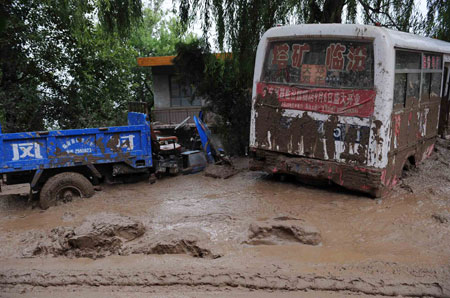 Vehicles destroyed by the mud-rock flow are seen in Xiangfen County of north China's Shanxi Province, September 8, 2008. At least 26 people were killed on Monday in a rain-triggered mud-rock flow that caused the collapse of a warehouse holding waste ore dregs in Shanxi Province.