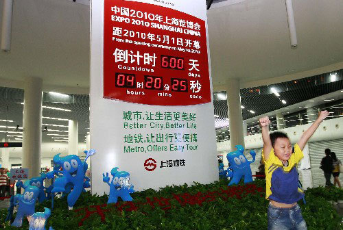 A kid poses for photos in front of a new countdown board for the 2010 Shanghai World Expo at the People's Square metro station in Shanghai on September 8, 2008. [Photo: Xinhua]