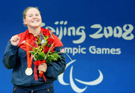 Anna Eames of the United States celebrates on the podium during the awarding ceremony of the S10 final of women's 100m butterfly of the Beijing 2008 Paralympic Games at the National Aquatics Center in Beijing, Sept. 8, 2008. She won the gold medal of the event with 1 min 09.44 seconds. (Xinhua/Yang Shiyao)