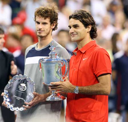 Roger Federer (R) of Switzerland holds the trophy for his fifth straight U.S. Open title, as Andy Murray (L) of Britain stands next, after the men's final match at the U.S. Open tennis tournament at Flushing Meadows in New York Sept. 8, 2008.