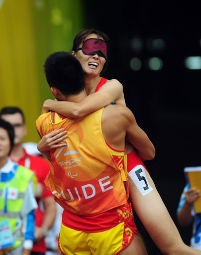 Wu Chunmiao celebrates with her guide after winning the Women's 100m T11 gold medal at the National Stadium, also known as the Bird's Nest, in Beijing on September 9, 2008.