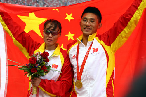 Wu Chunmiao (L) and her guide pose for a photo after winning the Women's 100m T11 gold medal at the National Stadium, also known as the Bird's Nest, in Beijing on September 9, 2008. 