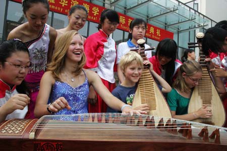  German students learn playing Chinese folk musical instruments in Yaohua Binhai School in north China's Municipality of Tianjin, Sept. 6, 2008. Eight children of German employees with the Tianjin-based Airbus assembly plant started their study of Chinese language and culture in the school on Saturday. 