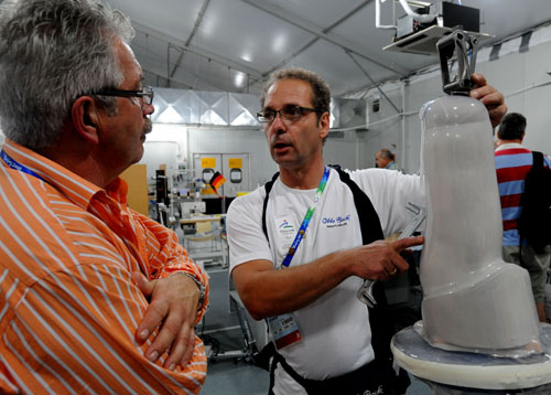 A technician in the maintenance center discusses with an athlete how to fix his artificial limb, Sept 8. [Wang Xiaochuan/Xinhua] 