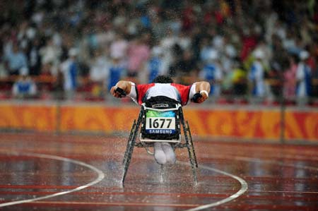 Japan's Susumu Kangawa competes in the rain during the first round competition of men's 400m T53 of the Beijing 2008 Paralympic Games, at the National Stadium, also known as the Bird's Nest, in Beijing, China, Sept. 9, 2008. (Xinhua/Li Ga)