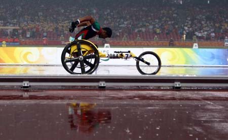 Mohammad Vahdani of the United Arab Emirates competes in the rain during the first round competition of men's 400m T53 of the Beijing 2008 Paralympic Games, at the National Stadium, also known as the Bird's Nest, in Beijing, China, Sept. 9, 2008. (Xinhua/Zhang Yanhui)