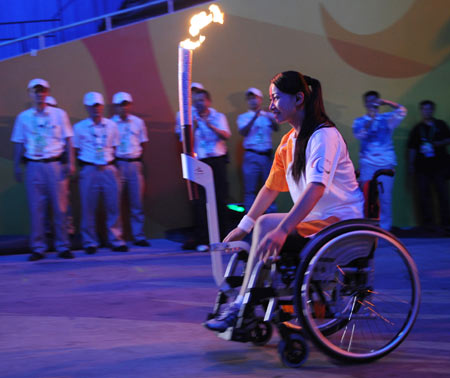 Chinese Paralympian fencer, Jin Jing, rolls her wheelchair bearing the Paralympic torch during the torch relay at the opening ceremony of the 2008 Beijing Paralympics Sept. 6, 2008. Jin lost her right leg to a malignant tumor at the age of 18 and is now uses a wheelchair. She moved people by protecting the Olympic torch from attackers in the Paris leg of the torch relay.