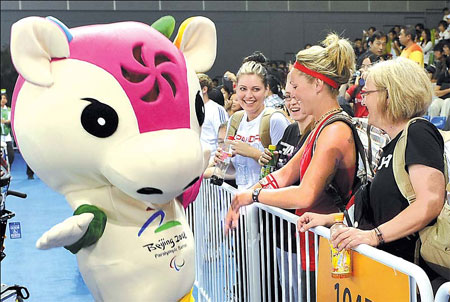 Amusing interlude: A group of spectators enjoys the antics of a volunteer dressed as the Paralympic mascot Le Le yesterday at the National Conventional Center. The cute cow struts her stuff between events to keep the crowds entertained.
