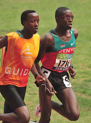 Kenya's Samwel Mushai Kimani (R) competes with the guide during the first round competition of the men's 800M T12 at the National Stadium，also known as the Bird's Nest, at the Beijing 2008 Paralympic Games in Beijing, China, Sept. 8, 2008. 