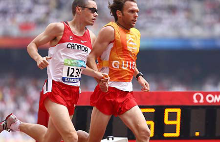 Canana's Dunkerley Jason (L) competes with the guide during the first round competition of the men's 800M T12 at the National Stadium，also known as the Bird's Nest, at the Beijing 2008 Paralympic Games in Beijing, China, Sept. 8, 2008. 