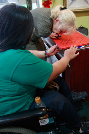 A female paralympian writing a good luck message to China in the Beijing Paralympic Village, September 9, 2008 [Zhnag Yunxing/China.org.cn]